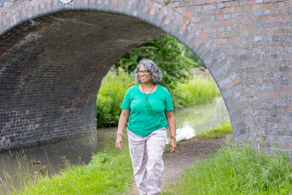 Woman in green t-shirt walking by a canal